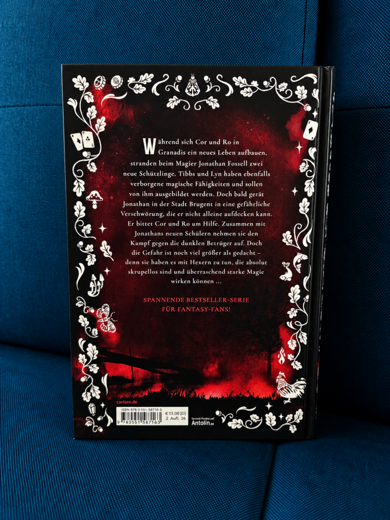 Fantasy-Jugendbuch „Stadt der Hexer und Betrüger“ von Judith Mohr aus dem Carlsen Verlag auf einer mintgrünen Decke in einem gemütlichen Teenagerzimmer als perfekte Urlaubslektüre.
